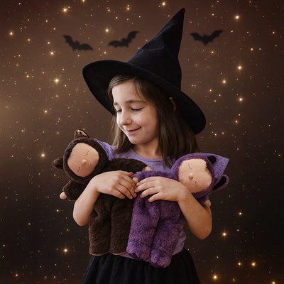 Child in witch costume holding plush toys against a Halloween-themed background with bats and stars.
