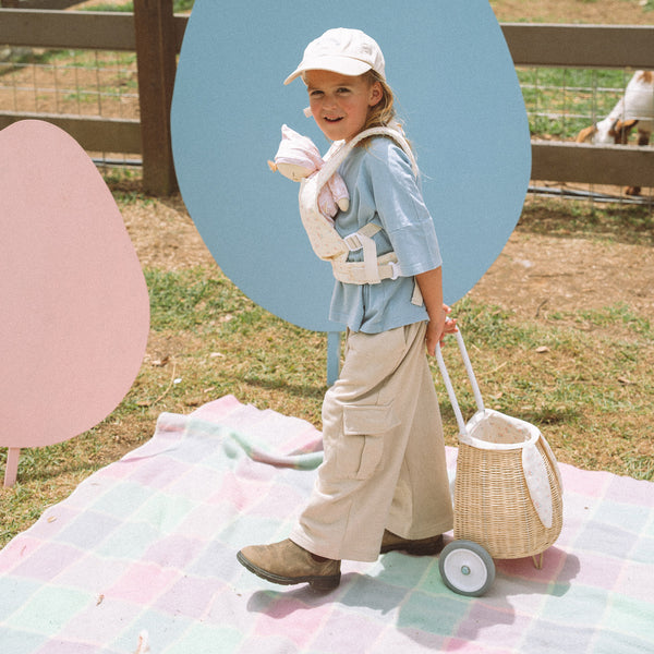 Woven rattan basket on wheels with printed flower lining. Perfectly sized for your kid to transport their favourite toys, dolls and treasures on their adventures.