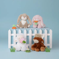 Four plush toys on a small white picket fence against a light blue background