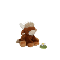 Plush toy cow with a small flower on a white background