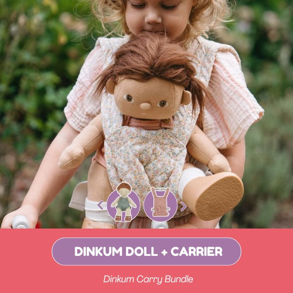 Child holding a doll with a carrier, set against a natural background