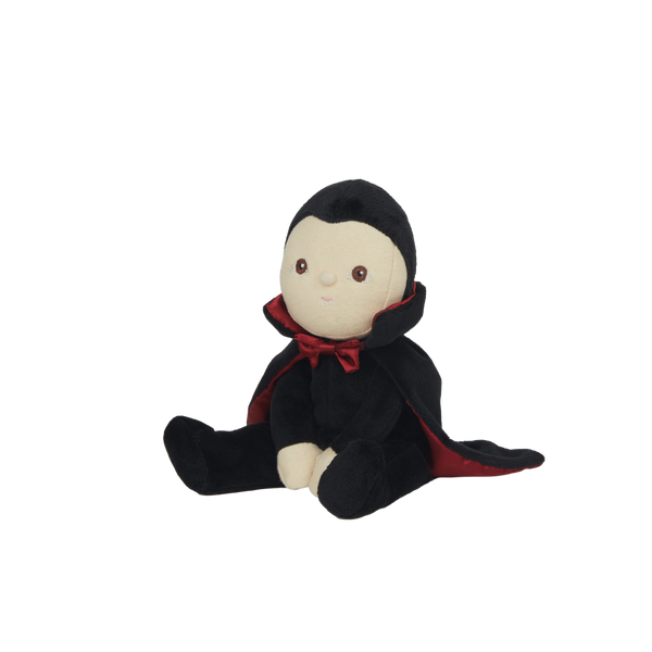 Stuffed toy dressed as a vampire with a black cape and red collar on a white background
