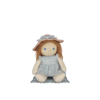 Stuffed doll with a pink hat and gray dress on a white background