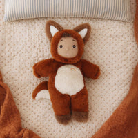 Plush toy fox lying on a textured surface