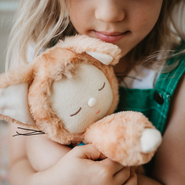 Little girl playing with ginger tabby cat, soft plush toy doll for kids