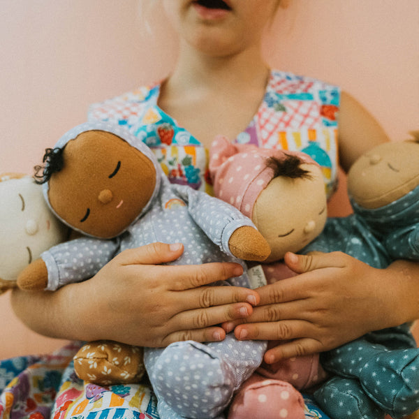 Gender-neutral posable plush doll with purple velvety onsie outfit. Perfectly weighted for cuddles and bedtime. Suitable toy from birth.