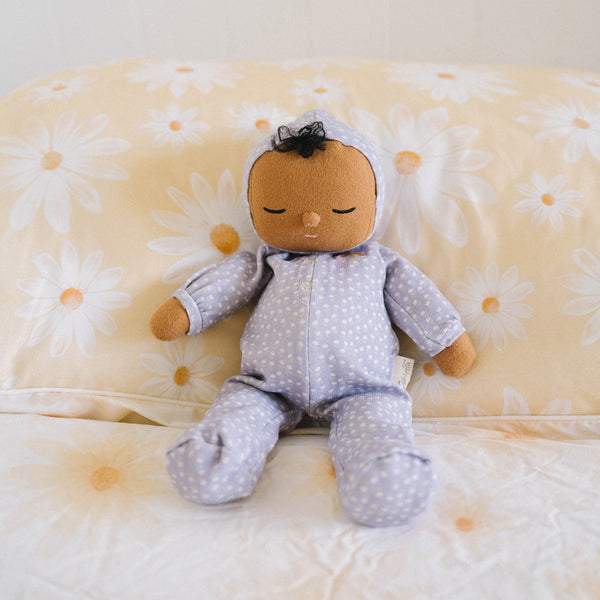 Dozy Dinkum doll with purple velvety onsie outfit. Perfectly weighted doll for calm. Plush doll with brown hair, perfect for cuddling and interactive doll play.
