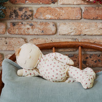 Olli Ella Christmas theme Dozy Dinkum with cream print laying on bed