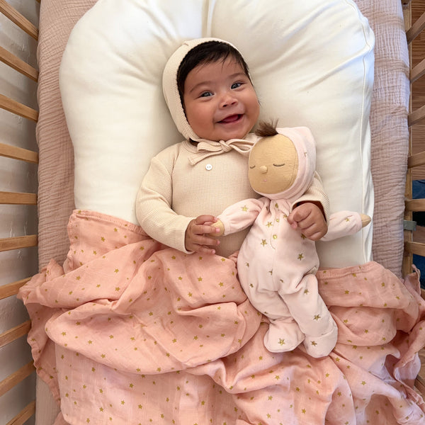 Pink posable plush doll suitable from birth. The Lullaby Luna includes a pompom on their bonnet that plays a sleepy tune when pulled. 