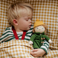 Child holding a doll with a checkered background