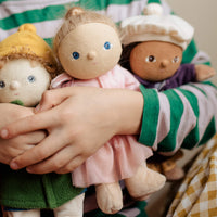 Child embracing three dolls
