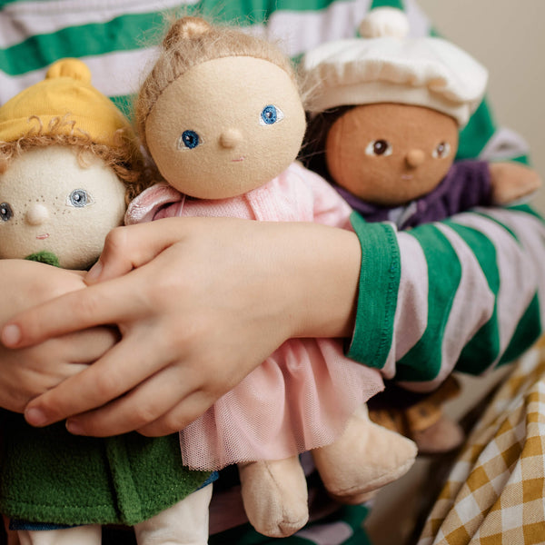 Child embracing three dolls