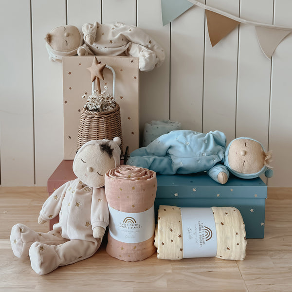 Keepsake gift set featuring a beautiful soft doll and matching swaddle cloth. The lullaby Lyra includes a pompom on their bonnet that plays a sleepy tune when pulled, perfect for soothing newborns, making it the perfect gift for newborns and expecting parents.