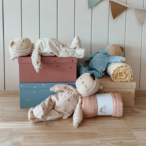 Keepsake gift set featuring a beautiful pink soft doll and matching swaddle cloth. The lullaby Luna includes a pompom on their bonnet that plays a sleepy tune when pulled, perfect for soothing newborns, making it the perfect gift for newborns and expecting parents.