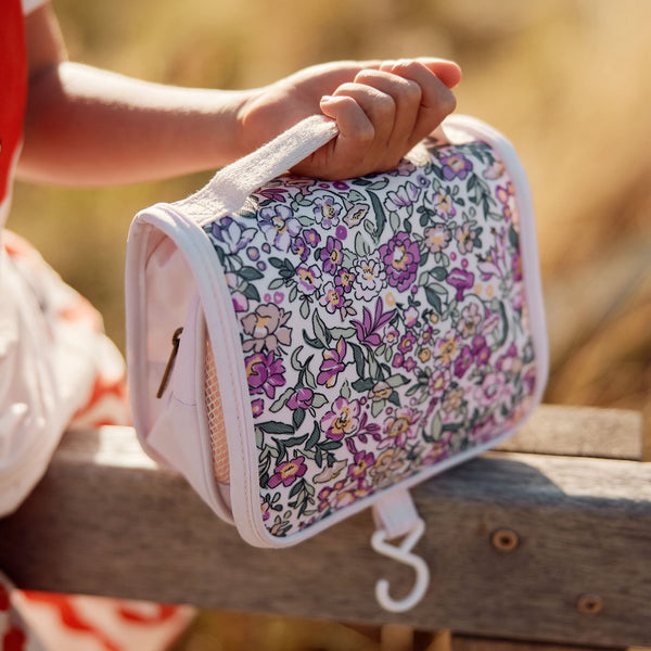 Compact, durable kids flower printed toiletry bag by Olli Ella. Perfect for toiletries and travel essentials. Ideal for organized packing, made from eco-friendly materials.